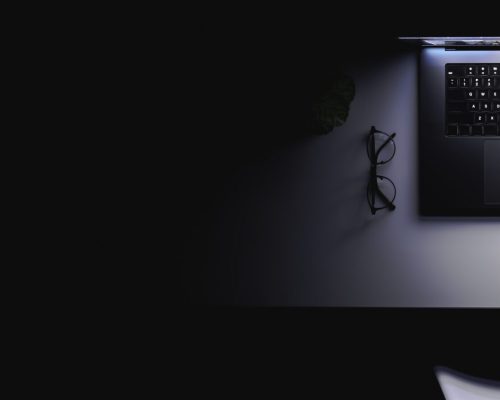 laptop-with-glowing-screen-table-dark-top-view-copy-space.jpg